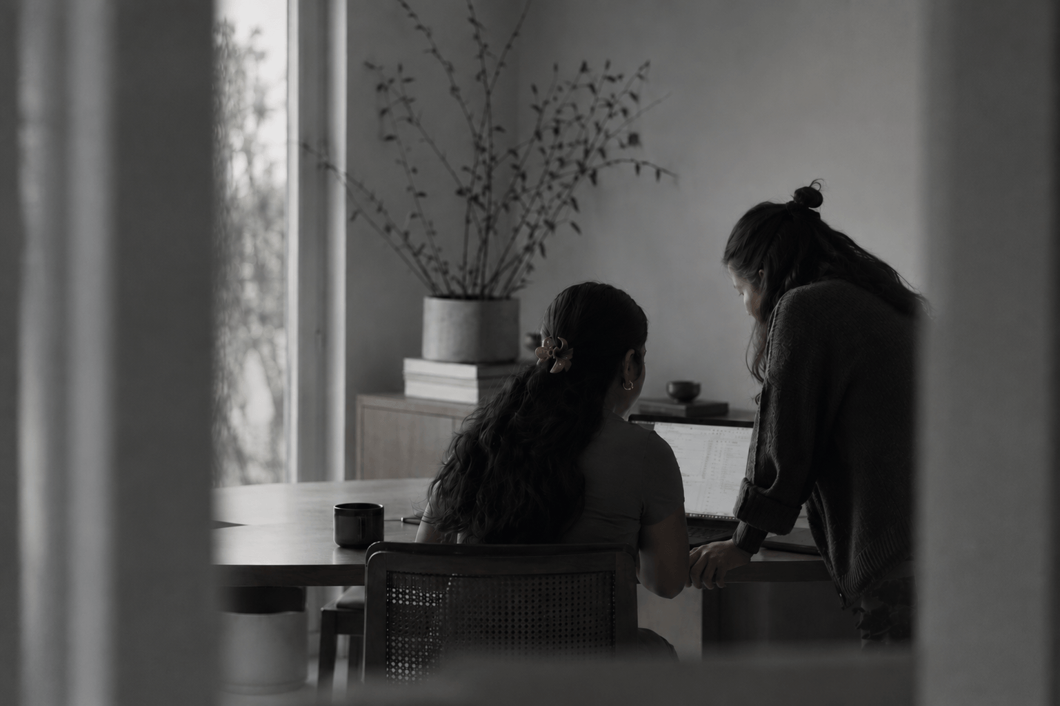 Two colleagues smiling and reviewing work together at a desk